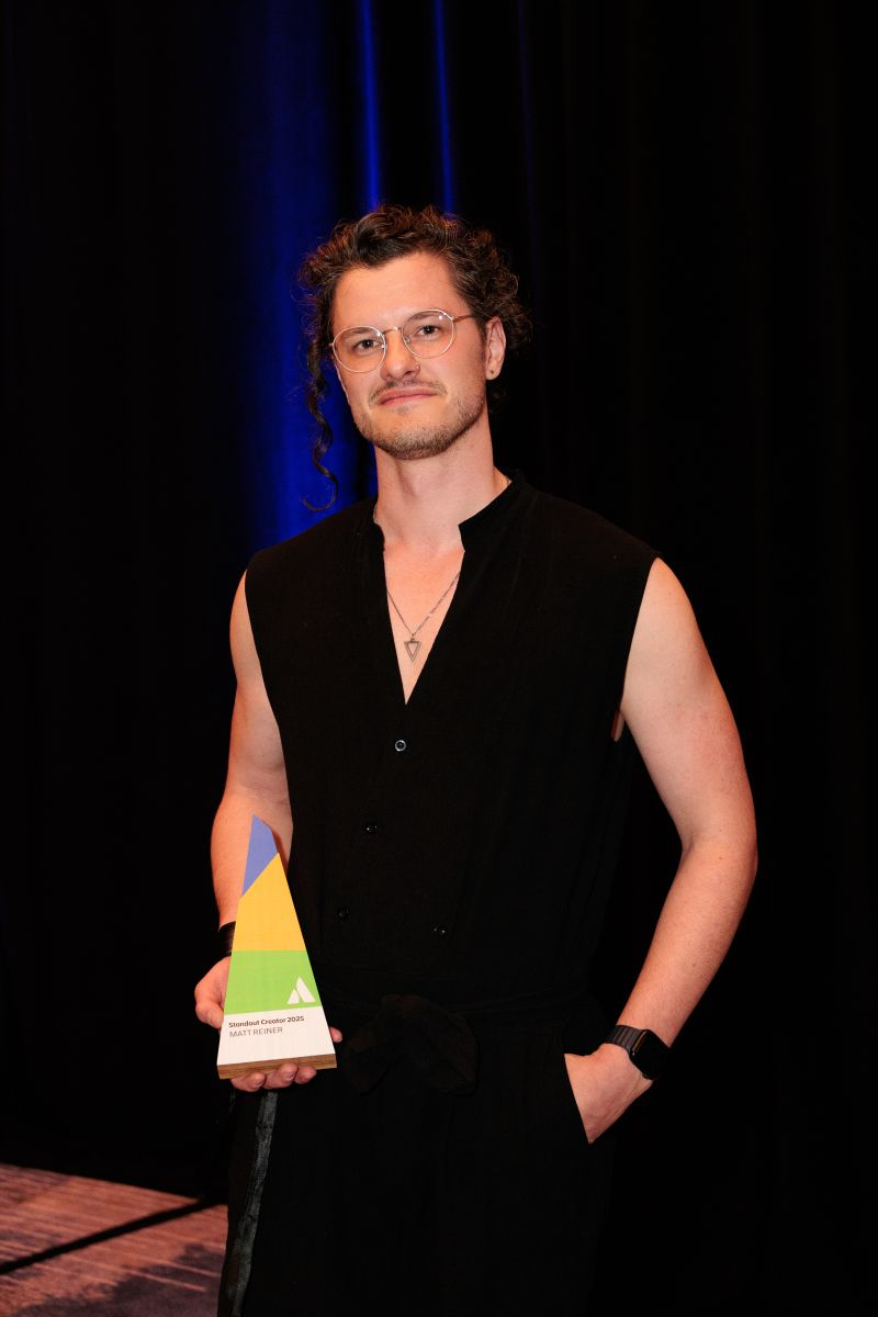 K15t's Matt Reiner smiling and holding the (Standout Creator Award 2025) trophy on stage at a previous Atlassian event.